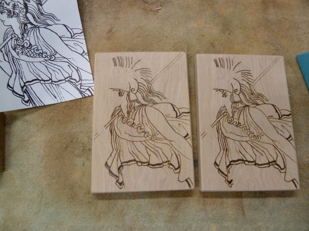 The image of Athena burned into both pieces of wood.