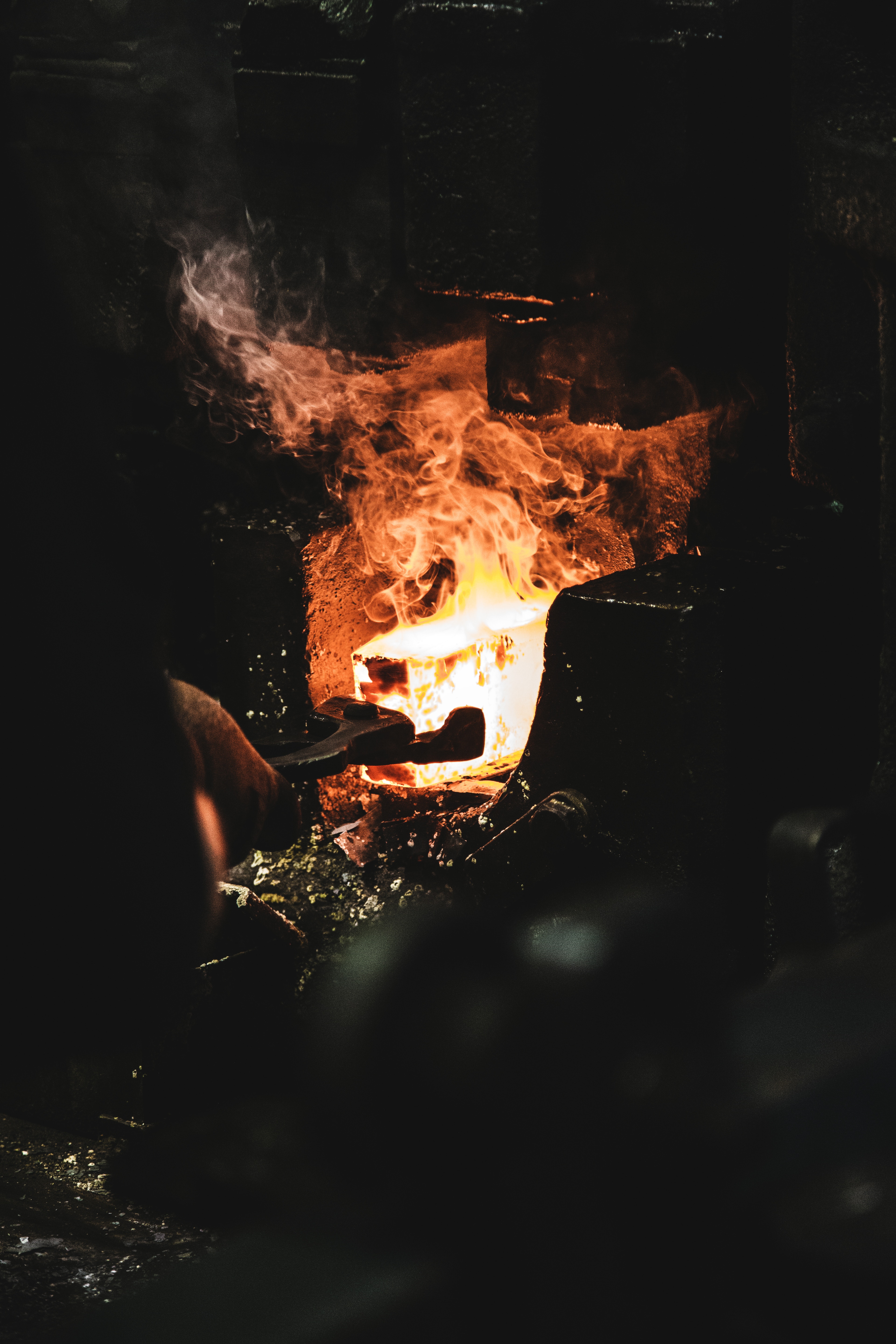 A person melting iron in a forge